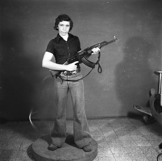 boy poses with automatic rifle