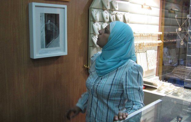 A Saida jeweller looks at Madani's historic photo of her shop.
