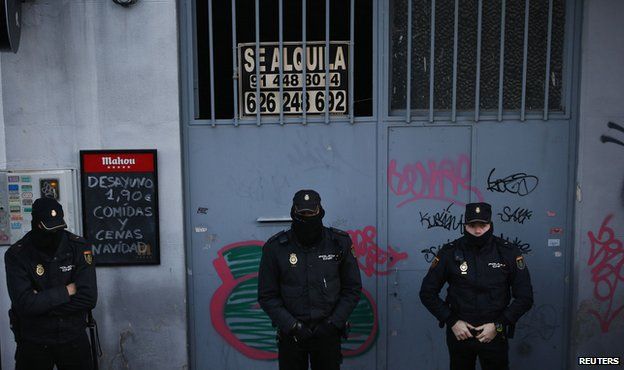 Police outside a home as they wait to carry out an eviction in Madrid December 11, 2013.