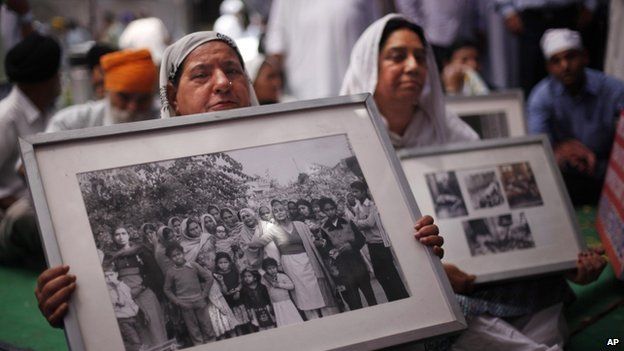 Indian Sikh women hold photographs of riot victims as they protest the acquittal of ruling Congress party leader Sajjan Kumar, in New Delhi, India, 7 May 2013