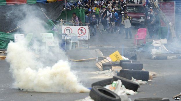 Thai anti-government protesters run from tear gas after police demanded they leave the area around the Government House in Bangkok on 18 February 2014