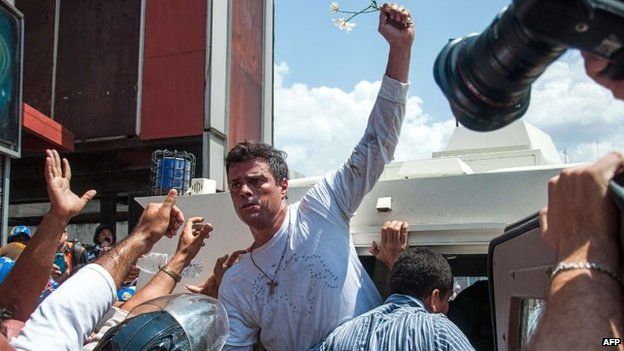 Leopoldo Lopez is escorted by the National Guard into a vehicle after he turned himself in