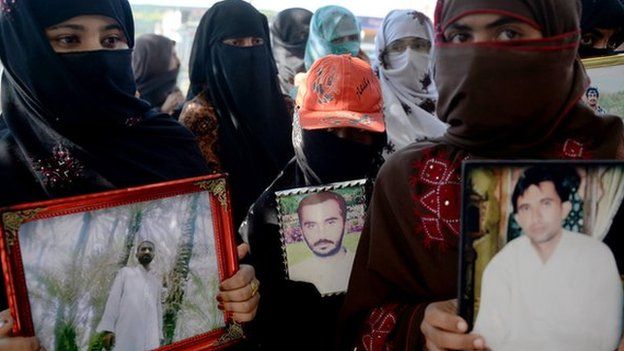 Pakistani Baloch women carry photographs of missing ethnic Balochs at Hub district as they march towards Karachi from Quetta, the capital of Baluchistan Province on 21 November 2013