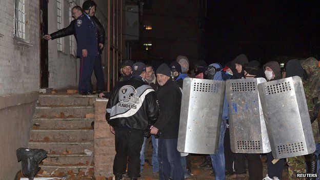 Protesters stand outside a riot police base in the town of Rivne in western Ukraine on 19 February.