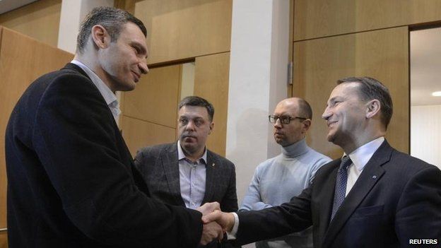 Polish Foreign Minister Radek Sikorski shakes the hand of Ukrainian opposition leader Vitaly Klitschko, as Oleh Tyahnybok and Arseniy Yatsenyuk look on, Kiev (20 Feb)