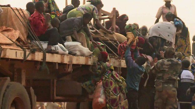 Muslim getting on to a truck, part of a convoy leaving Bangui to CAR