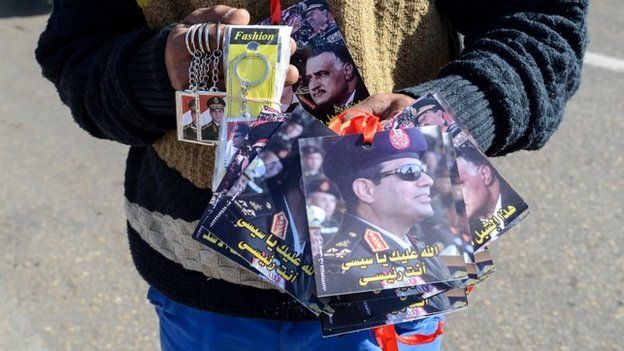 A young Egyptian sells key rings and portraits of Abdul Fattah al-Sis in Cairo's Tahrir Square (28 January 2014)