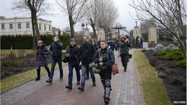 Journalists and protesters enter the presidential residential compound north of Kiev