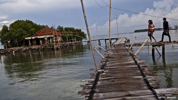 Villagers walk over bamboo bridges in central Java
