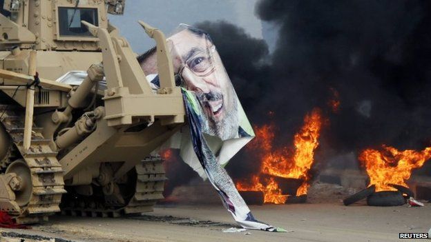 A torn poster of deposed Egyptian President Mohammed Morsi on a bulldozer as security forces clear Cairo's Rabaa al-Adawiya square (14 August 2013)