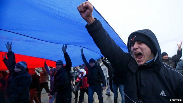 People march under a giant Russian flag in Simferopol, Crimea, on 27 February 2014