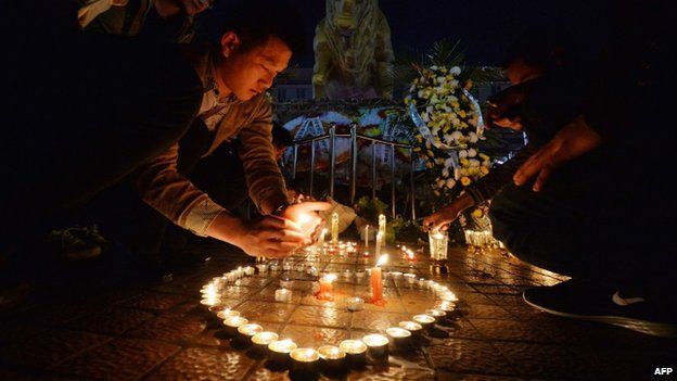 Chinese mourners light candles at the scene of the knife attack at the main train station in Kunming, Yunnan Province on 2 March 2014