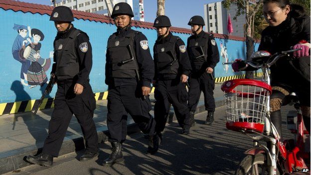 Armed policemen patrol on a street near the Kunming Railway Station in western China's Yunnan province, 3 March 2014