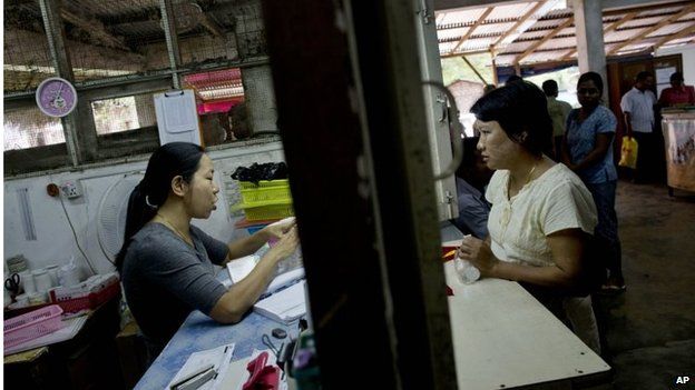 A patient, right, receives medicine at a clinic for HIV and Tuberculosis patients, run by Medecins Sans Frontieres in Yangon in April 2013
