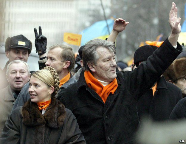Viktor Yushchenko (R) and Yulia Timoshenko (L) greet supporters during a rally outside House of Ukrainian Parliament in Kiev, 23 November 2004