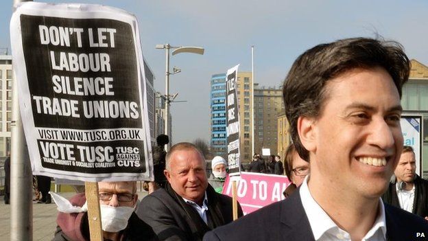 Protesters behind Mr Miliband