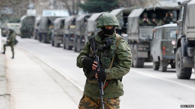 Armed serviceman stands by Russian army vehicles in the Crimean town of Balaclava on 1 March 2014
