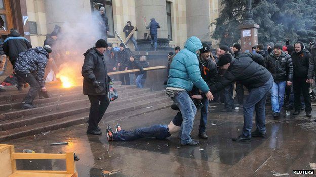 Pro-Russian protesters drag away a wounded man during clashes with rival protesters in Kharkiv on 1 March 2014
