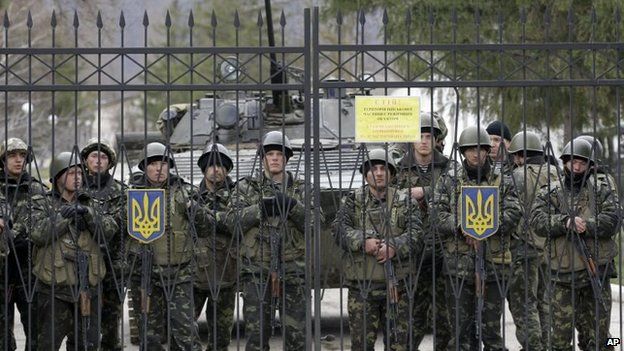 Ukrainian soldiers guard a gate of an infantry base in Perevalnoye