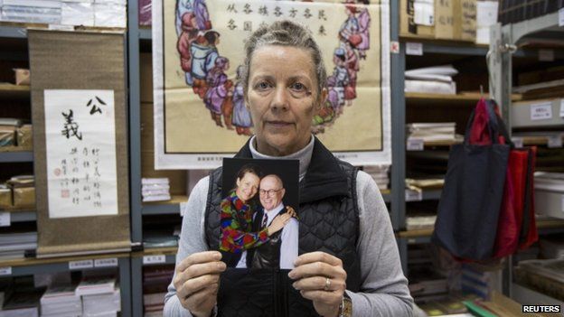 Karen Short, wife of Australian missionary John Short, poses with a photo of her husband inside the Christian Book Room in Hong Kong 20 February 2014