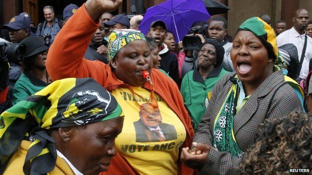 Members of the African National Congress Women's League sing in front of the courthouse ahead of the trial of Olympic and Paralympic track star Oscar Pistorius at the high court in Pretoria, 3 March 2014