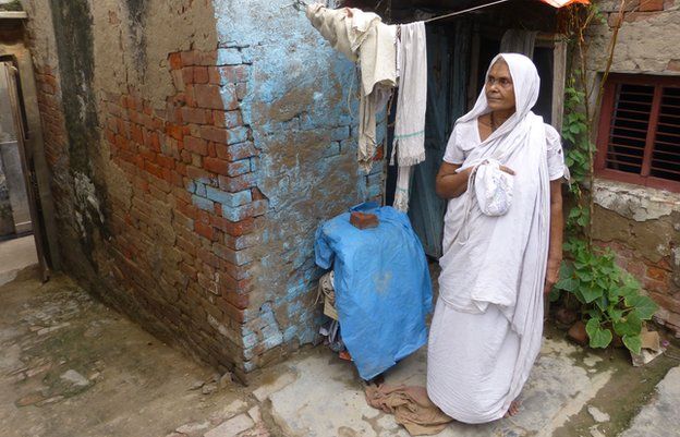 Shakti Dasi outside her small brick shack in Vrindavan