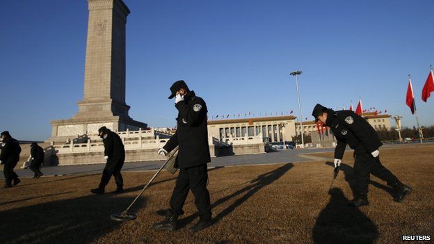 Police use metal detectors outside the Great Hall of the People at Tiananmen Square during the opening session of the National People's Congress (NPC) in Beijing, 5 March 2014