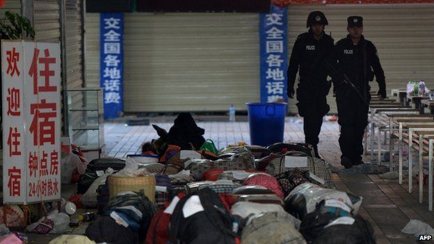 Chinese police walk past abandoned luggage at the scene of an attack at the main train station in Kunming, Yunnan province on 2 March 2014
