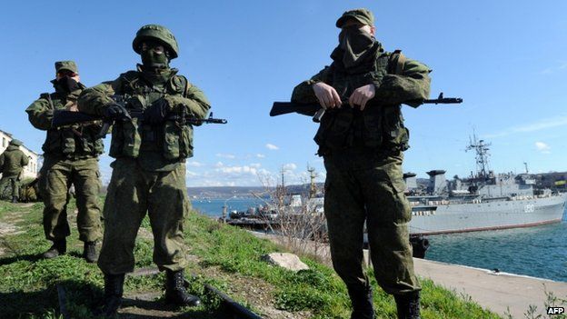 Armed men - believed to be Russian troops - patrol near the Ukrainian navy ship Slavutych in Sevastopol. Photo: 5 March 2014