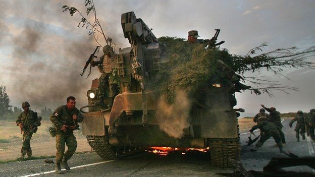 Georgian soldiers flee their burning armoured vehicle during the conflict with Russia in 2008