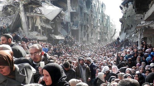 A vast crowd of people queue for aid at the Yarmouk refugee camp near Damascus