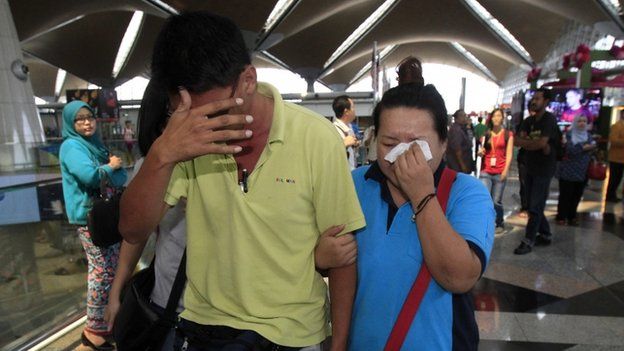 A woman wipes her tears after walking out of the reception centre and holding area for family and friends of passengers aboard a missing Malaysia Airlines plane at Kuala Lumpur International Airport, 8 March