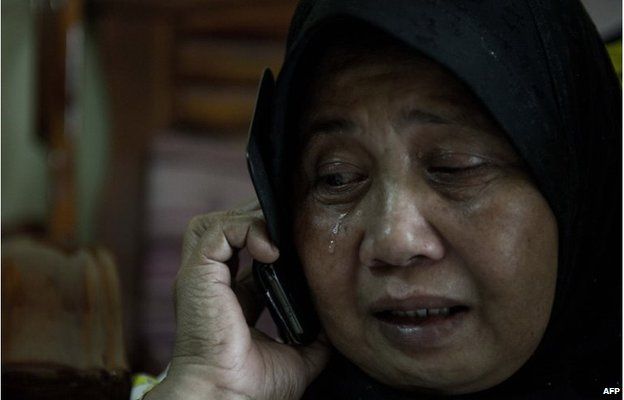 A relative of two passengers on the missing plane, cries at their house in Kuala Lumpur