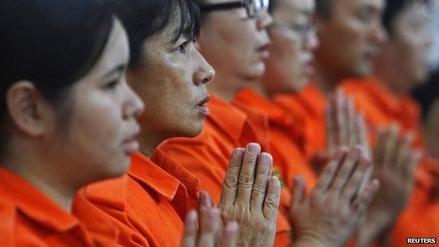 Rescue workers from a Buddhist organisation pray during multi-religion mass prayers for the passengers of Malaysian Airlines flight MH370, 9 March