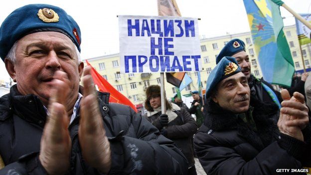 Former Russian paratroopers applaud during a pro-Russian rally in the Ukrainian region of Crimea