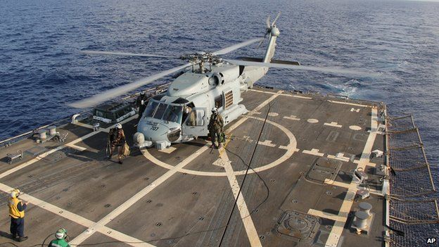A U.S. Navy helicopter lands aboard Destroyer USS Pinckney during a crew swap before returning to a search and rescue mission for the missing Malaysian airlines flight MH370 in the Gulf of Thailand, Sunday, March 9, 2014