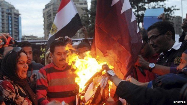 Egyptians burn the Qatar's flag outside its embassy in Cairo (30 November 2013)