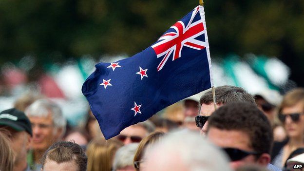 A man holds a New Zealand flag at a ceremony in Christchurch on 22 February 2012
