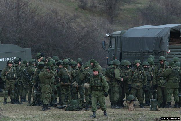 Troops under Russian command assemble before getting into trucks near the Ukrainian military base they are blockading on March 5, 2014 in Perevalne, Ukraine.