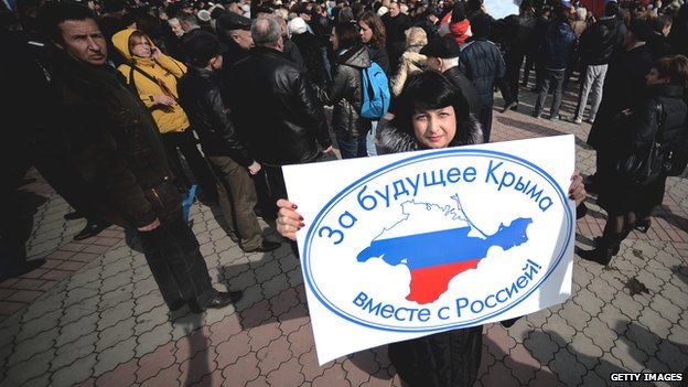 Pro-Russian demonstrator in Crimea, with sign reading, "For Crimea's future with Russia"