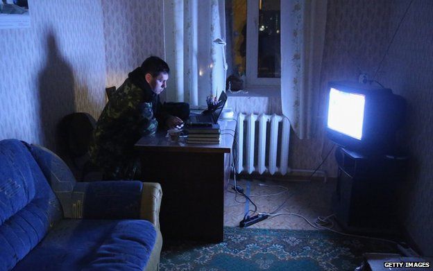 A Ukrainian soldier watches a news broadcast at the Belbek military base in Crimea (4 March)