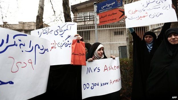 Members of the Basij militia hold banners criticising Catherine Ashton at a protest outside the Austrian embassy in Tehran on 12 March 2014