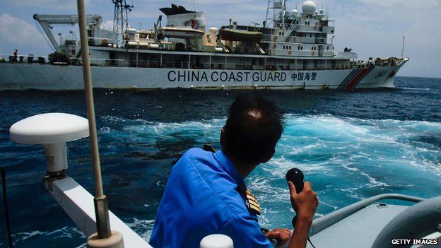 Member of Malaysia Navy makes a call as a Chinese Coast Guard ship passes close by in Kuantan, Malaysia, on 15 March 2014