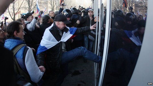 Pro-Russian activists try to storm into Ukraine's Security Service building following a rally in the eastern Ukrainian city of Donetsk on March 15