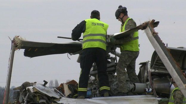 Crews work to removed rotor blades from the crashed AW139