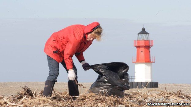 Woman collecting rubbish on beach