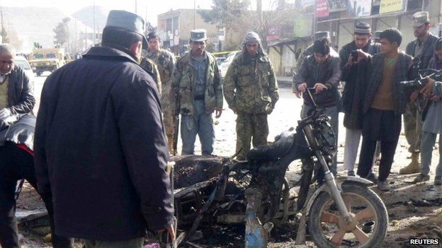 An Afghan police officer stands at the site of a suicide blast in Maymana, Faryab, northern Afghanistan on 18 March 2014