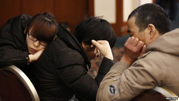 Family members of a passenger onboard the missing Malaysia Airlines flight MH370 react as they listen to a briefing from the airline company at a hotel in Beijing, 18 March 2014