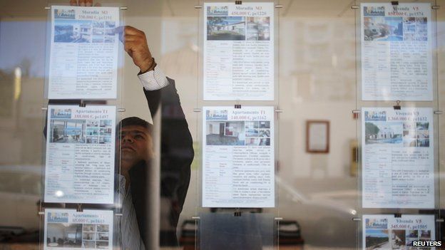 Vyacheslav Eshanu, head of Portugal Estate, places publicity notices on the glass wall of his office in Portimao on 11 November 2013.