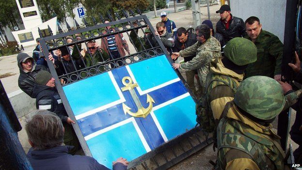 Pro-Russian protesters remove the gate of Ukraine's navy HQ in Crimea on 19 March 2014
